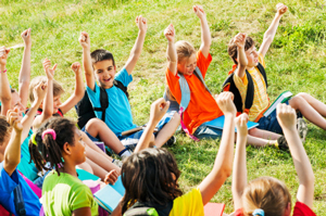 children sitting raising arms